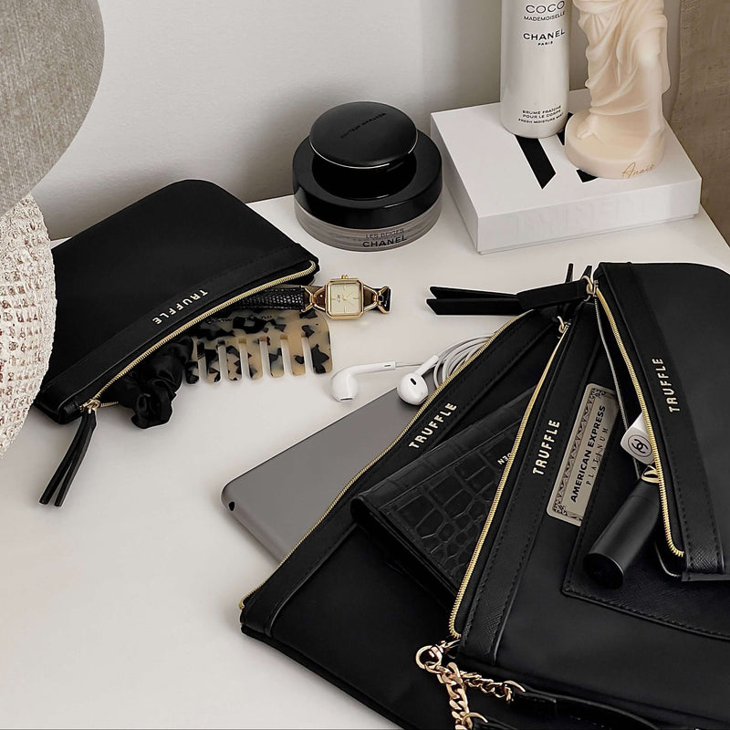 A set of four Truffle Clarity Privacy Multi-tasking Pouches, made with recycled nylon, filled wth essentials.