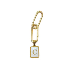 Two gold plated links attached to a small square white enamel charm with a gold border and the letter 'C' in gold, shown on a mother of pearl white background.