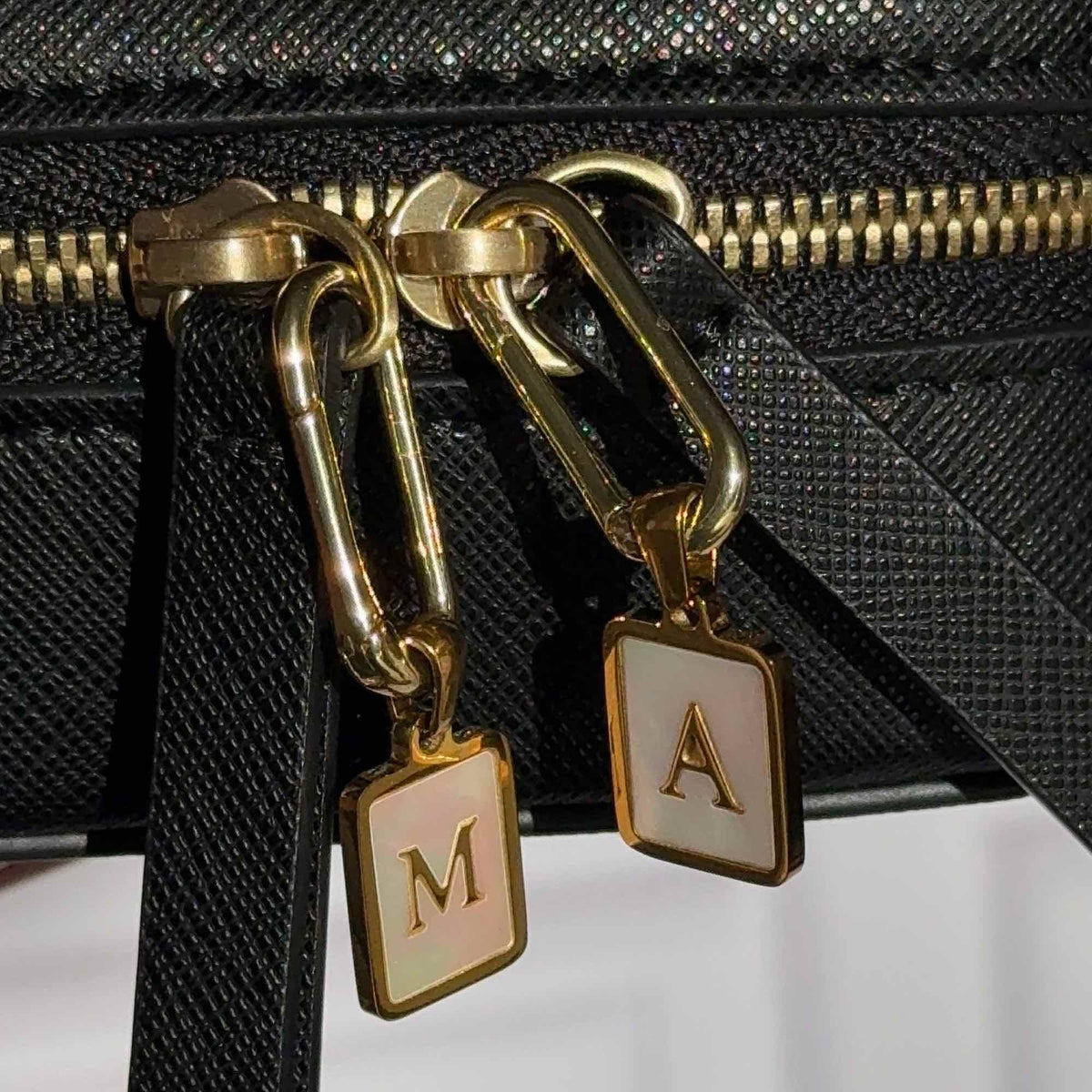 Two charms hanging from a Truffle Jewelry Case.