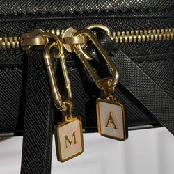Two charms hanging from a Truffle Jewelry Case.