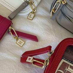 Letter harms hanging from the zipper pulls on different Truffle bags