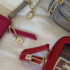Letter harms hanging from the zipper pulls on different Truffle bags