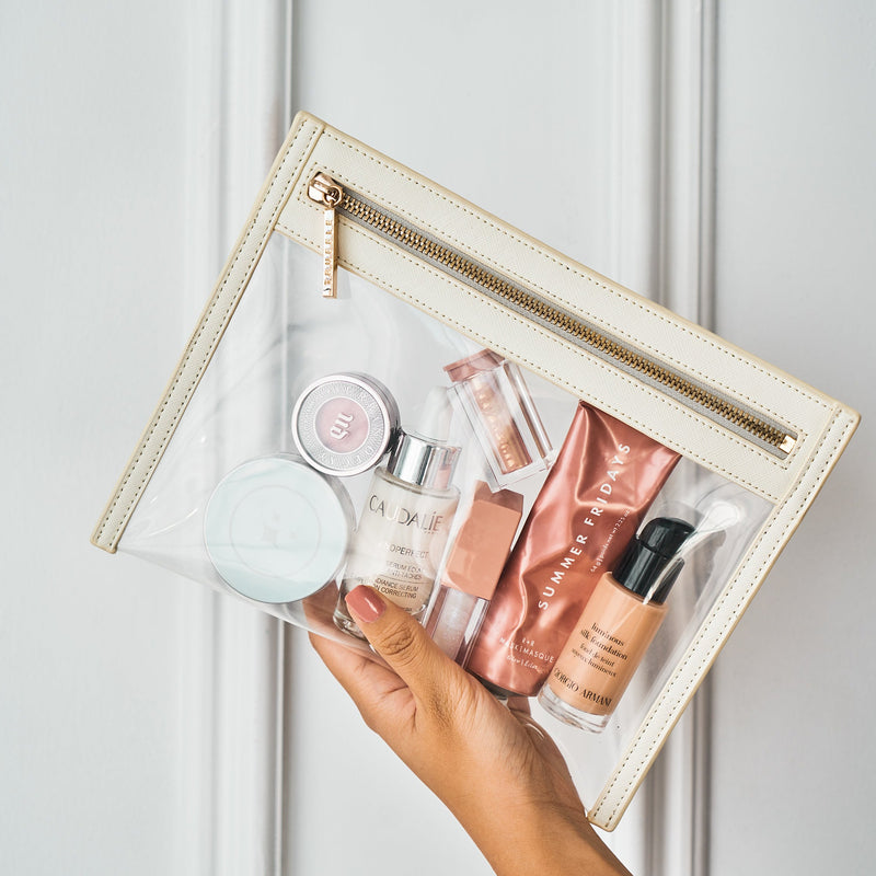 Truffle Clarity Clutch Small, a sleek, TSA-approved zippered pouch with clear TPU plastic and leather trim.